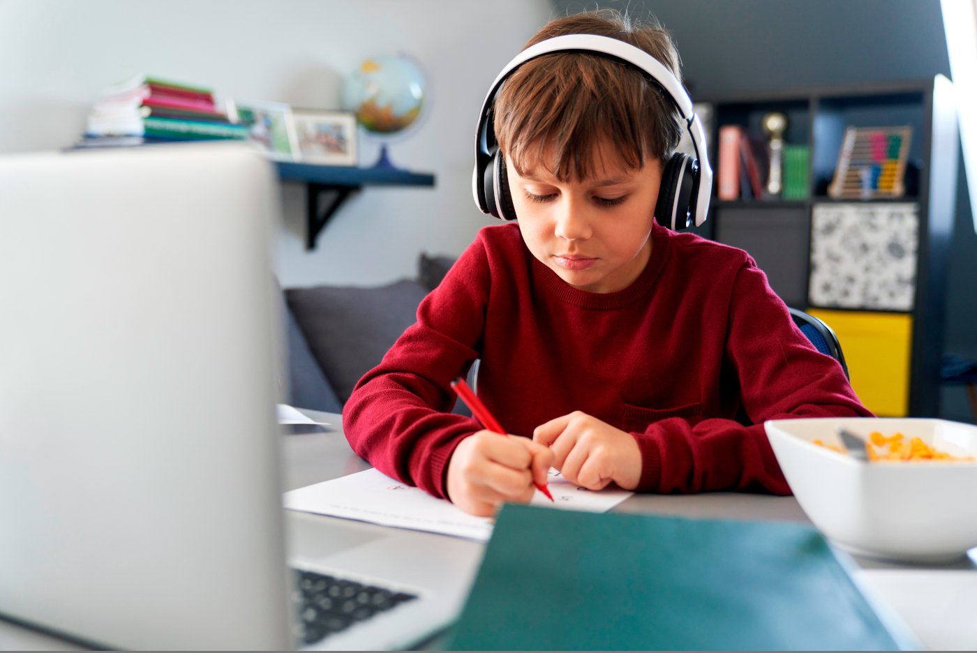 Niño preparándose la lección desde casa con los recursos ofrecidos en la academia online